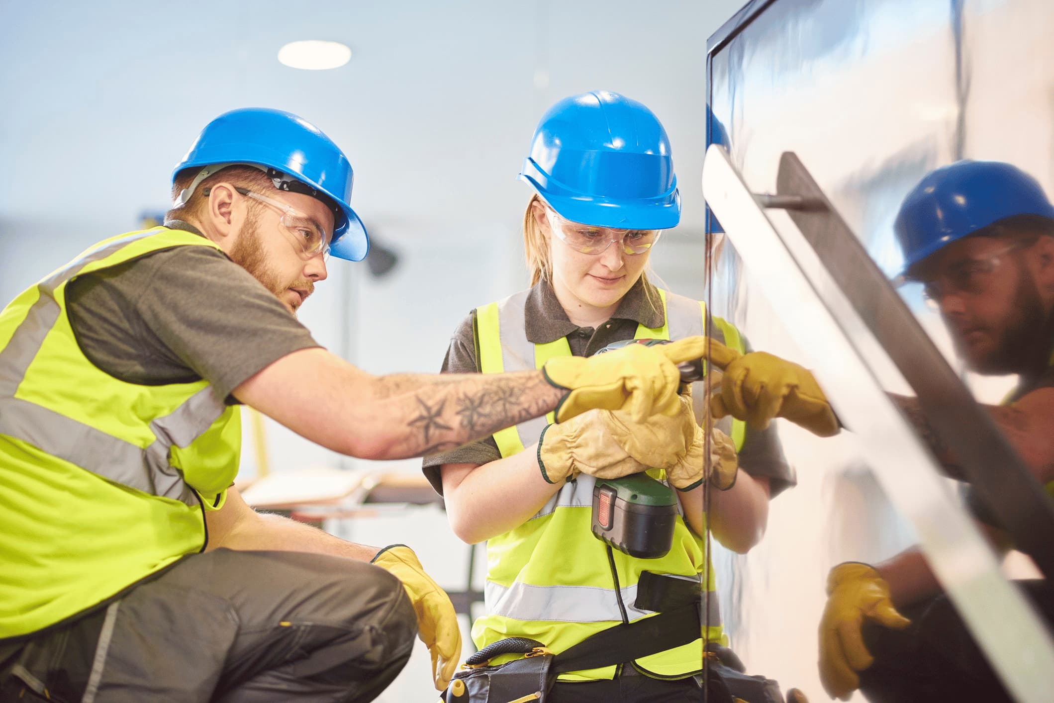 Female construction apprentice receiving instruction from another worker.