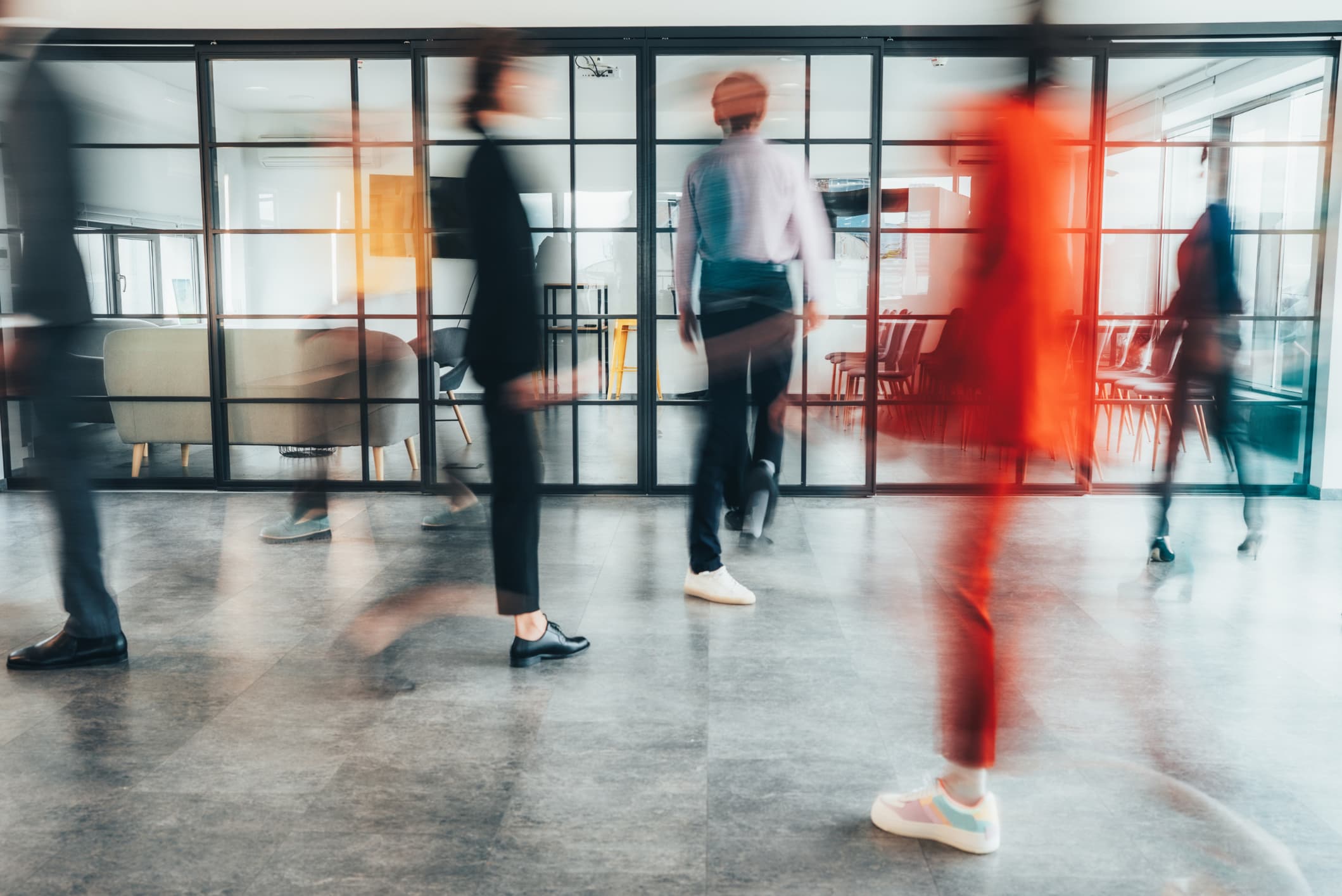 Blurred people walking through a modern office space.