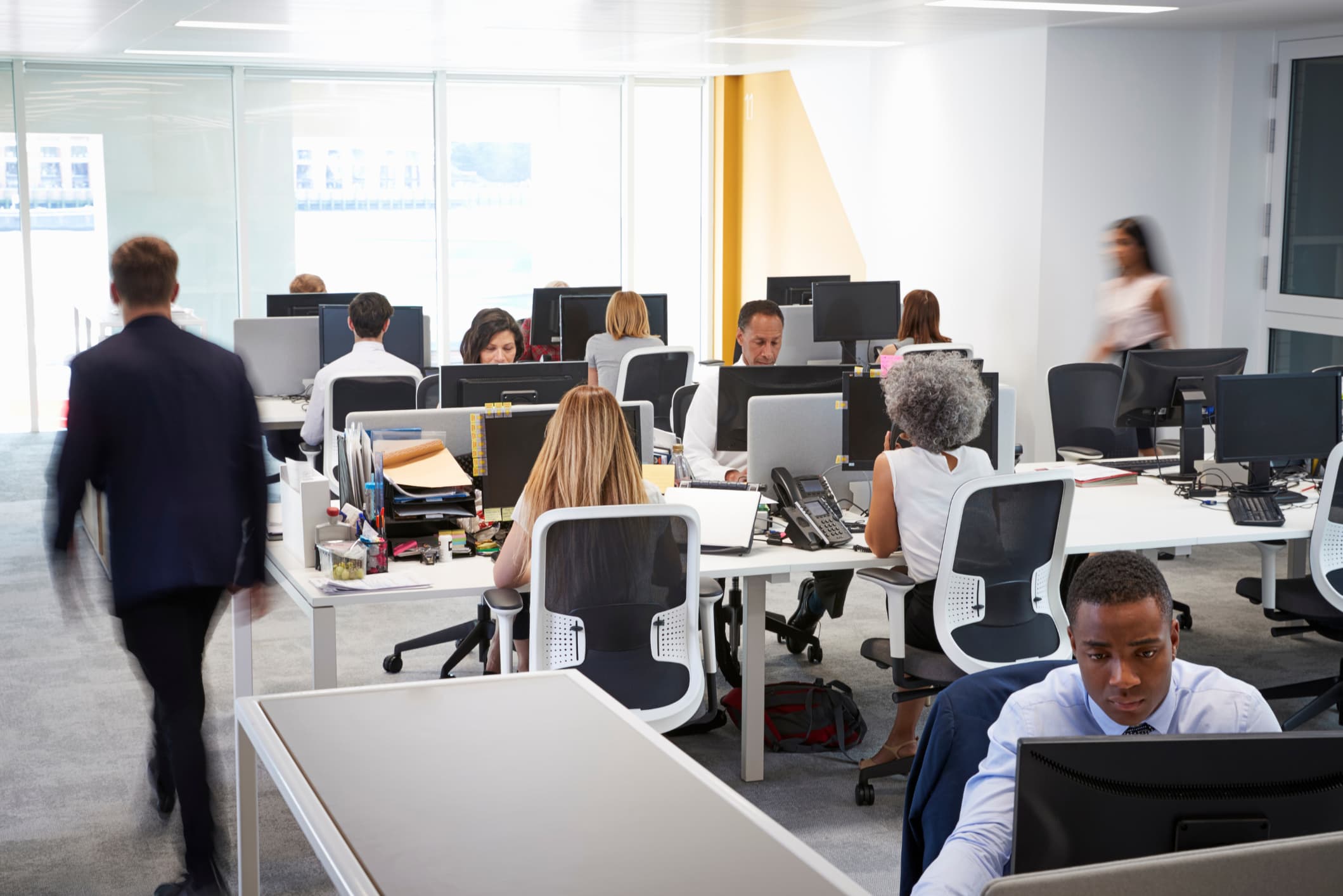 Man walking through a busy open plan office.